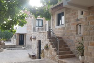 a stone house with stairs on the side of a building at Villa Žurnata in Bogomolje
