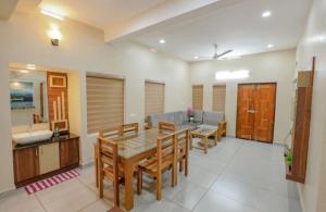 a kitchen and dining room with a table and chairs at Greenfield Homestay in Vythiri
