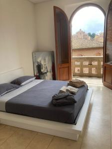 a large bed in a room with a large window at Splendida Vista su Siena in Siena