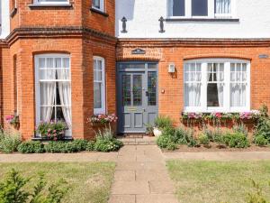 a brick house with a blue door and windows at 16 Garfield Road in Felixstowe