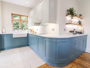 a kitchen with blue cabinets and a white sink at 16 Garfield Road in Felixstowe
