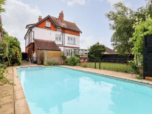 a large blue swimming pool in front of a house at 16 Garfield Road in Felixstowe