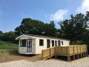 a small white tiny house with a wooden fence at Park gate house farm holidays, Colyton-‘Elizabeth in Colyton