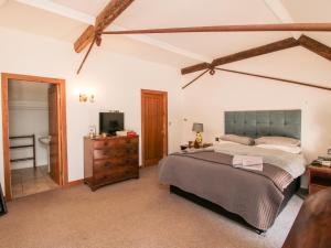 Talbot Lodge في ستافورد: غرفة نوم بسرير وخزانة وتلفزيون