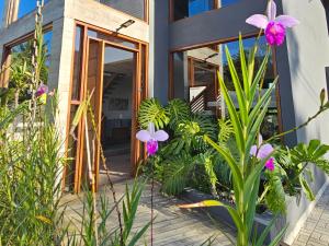 uma casa com flores roxas em frente a uma porta em Pousada Vila Ipuan em Paúba