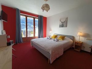 a bedroom with a bed and a large window at Hotel Plein Soleil in Allos
