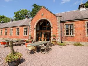 a brick building with a table and chairs in front of it at Chetwynd Lodge in Stafford