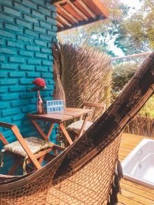 a hammock on a deck with a table and chairs at Pousada Bellatrix Ecolodge in Praia do Forte
