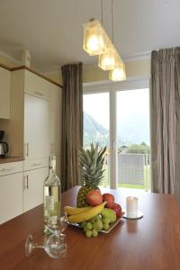 a table with a plate of fruit and a bottle of wine at Villa Castelli in Schladming