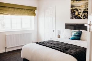 a bedroom with a large bed and a window at Hideaway by Liv Retreats in Lincoln