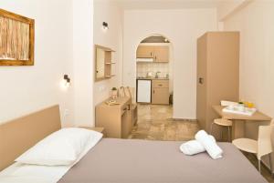 ein kleines Zimmer mit einem Bett und einer Küche in der Unterkunft Ambiance Studios in Masouri