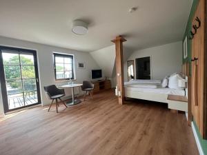 Schlafzimmer mit einem Bett, einem Tisch und Stühlen in der Unterkunft Hotel Ostseeland in Warnemünde