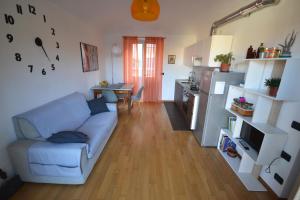 un salon avec un canapé bleu et une cuisine dans l'établissement Casa nel Borgo vicinissima al centro di Torino, à Turin 21 autres photos