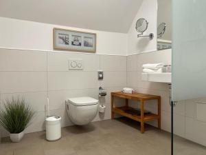 bagno bianco con servizi igienici e lavandino di Hotel Ostseeland a Warnemünde