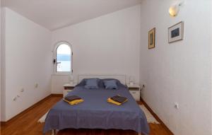 a bedroom with a bed with blue sheets and a window at Beautiful Apartment In Klek With Wifi in Klek
