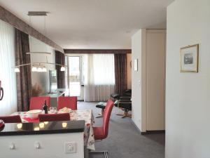 达沃斯Apartment Attika Wohnung Allod Park Haus C 801 by Interhome的客厅配有桌子和红色椅子