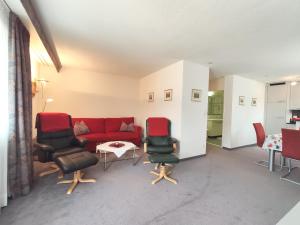 a living room with a red couch and chairs at Apartment Allod-Park-32 by Interhome in Davos