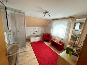 La salle de bains est pourvue d'une douche et d'un tapis rouge. dans l'établissement Apartment Kleeblatt by Interhome, à Breidscheid