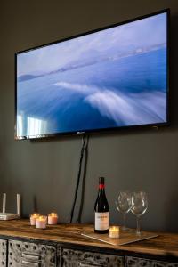 Eine Flasche Wein und zwei Gläser und ein Fernseher. in der Unterkunft Maravilloso Apartamento en Mijas Golf in Mijas