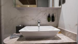 - un lavabo blanc dans la salle de bains pourvue d'une facette dans l'établissement President Hotel, à Dubaï