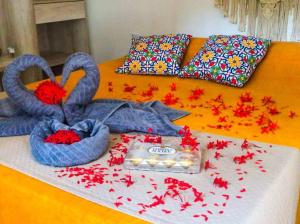 a bed with two swans with flowers on it at Pousada Paraíso do Vento in Cumbuco