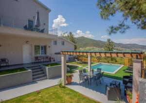 a villa with a swimming pool and a patio at Privileged villa in Nea Peramos