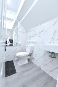 a white bathroom with a toilet and a sink at Stylish Studios by Luxestays Fulham in London