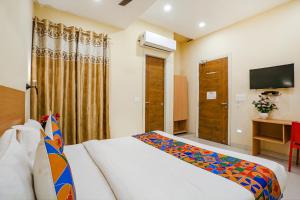 una camera d'albergo con letto e TV di FabHotel GK Residency a Nuova Delhi