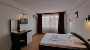 a bedroom with a bed and a desk and a window at Harmony Villa in Costinesti +14 photos