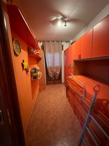 a bedroom with a bed with orange walls and a window at Casa Giusy in San Marzano di San Giuseppe
