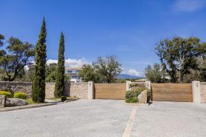 a driveway with a wooden fence and trees at Domaine d'Arca Flaubert 20 T2 4 pers in Porto-Vecchio
