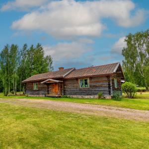 una cabaña de madera en un campo con un camino de tierra en Traditionell Timmerstuga - Mora, Gesunda, en Sollerön