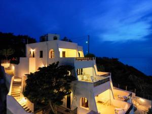 a large white building with stairs in front of the ocean at Pelagos Seafront Accommodation - George in Myrties