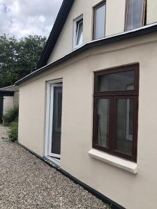 a white house with windows on the side of it at Retro-Sonnenbring B&B in Sønderborg