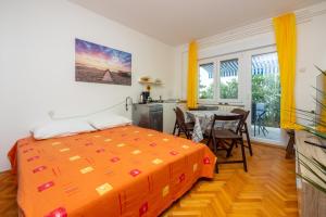 um quarto com uma cama e uma mesa com cadeiras em Apartmani Azur em Dramalj