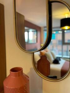 a vase sitting on a table in front of a mirror at Paramount city living 105 in Swindon