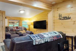 ein Wohnzimmer mit einem Sofa und einem Flachbild-TV in der Unterkunft Peach Creek Lodge in Kiker
