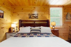 ein Schlafzimmer mit einem Bett in einem Blockhaus in der Unterkunft Peach Creek Lodge in Kiker