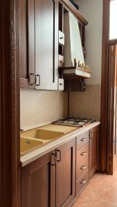 a kitchen with wooden cabinets and a stove top oven at Casa Giusy in San Marzano di San Giuseppe
