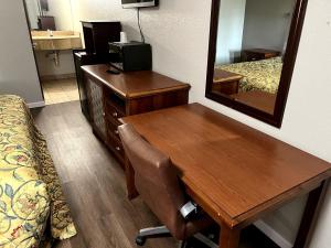 a hotel room with a desk and a mirror at Budget Plaza Motel in Brooklyn Park