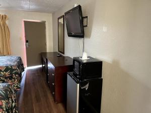 a room with a bed and a tv on a wall at Budget Plaza Motel in Brooklyn Park