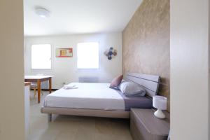 1 dormitorio con cama, mesa y ventanas en Affittacamere Mi Sueño, tranquillità nella natura, en Martignacco