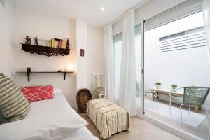 a living room with a bed and a large window at Ancha 9 in Sanlúcar de Barrameda