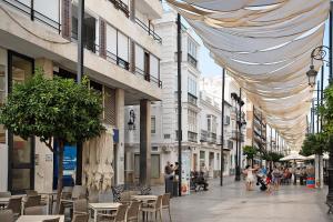 a city street with tables and chairs and buildings at Ancha 9 in Sanlúcar de Barrameda