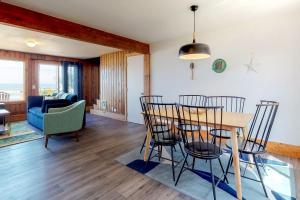 a dining room and living room with a table and chairs at Cape Cod Cottages - #2 in Waldport