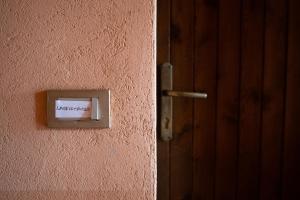 a lightswitch on a pink wall next to a door at Orchidea Apartment in Soiano del Lago
