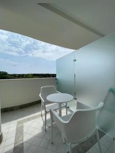 um pátio com uma mesa e cadeiras numa varanda em Milena Suite Apartments em Alghero
