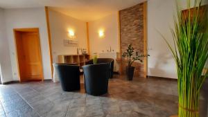 eine Lobby mit einem Tisch, Stühlen und Pflanzen in der Unterkunft Haus Alexandra Apartment in Bled
