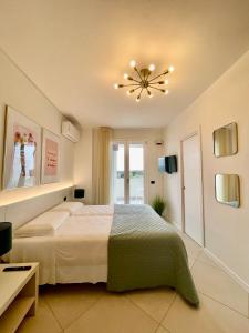 um quarto com uma cama e um lustre em Milena Suite Apartments em Alghero