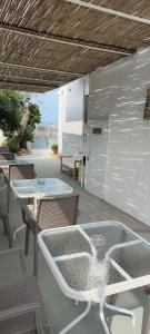 a patio with two tables and chairs and a table and chairs at Il Mirto Blu in Porto Cesareo